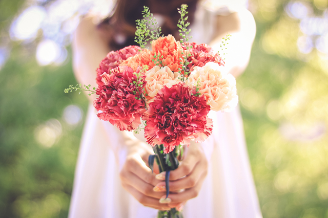 カーネーションの花束を渡す女の子